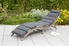 A lounge chair on a patio with plants in the background. Produktbild-Vorschau