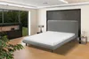 A modern bedroom with a bed, nightstand, and a large window overlooking a garden. Produktbild-Vorschau