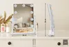 A white makeup mirror with lights is displayed on a dresser, with decorative items in the background. Náhľad obrázku produktu