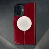 A close-up shot of a red leather iPhone case with a white MagSafe charger attached. Anteprima dell’immagine prodotto