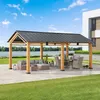 A wooden gazebo with a dark roof is set up on a paved patio, overlooking a body of water. Outdoor furniture, including a sofa and dining set, is arranged under the gazebo. Náhled obrázku produktu