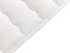 A close-up view of a white mattress topper with quilted patterns and a stitched edge. Náhled obrázku produktu