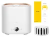 A white humidifier with a gold accent ring and a digital display on the front, shown next to its packaging and a filter accessory. Náhled obrázku produktu