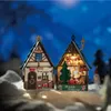 Two miniature Christmas houses are displayed in a snowy, nighttime setting. Produktbild-Vorschau