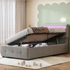 A bedroom scene with a bed that has its storage compartment open, revealing items inside. The bed has LED lighting in the headboard. Produktbild-Vorschau