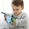 A baby is holding a toy. Produktbild-Vorschau
