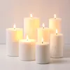 A group of seven white LED candles of varying heights are arranged on a white surface against a light gray background. Podgląd zdjęcia produktu