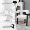 A white fluffy accent chair with black metal legs is shown in a room with a fireplace. Produktbild-Vorschau