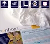 A white textile product is draped over marketing materials with text and images. Podgląd zdjęcia produktu