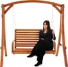 A woman is sitting on a wooden garden swing. Náhled obrázku produktu