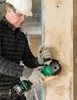 A construction worker is using an angle grinder on a wooden beam. Voir les images du produit