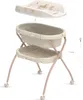 A baby bathtub with a stand and a changing mat. Produktbild-Vorschau