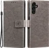 A gray flip case for a Samsung Galaxy A54 5G phone with a mandala pattern embossed on it. The case is shown open, with the phone inserted in one half and the cover flap folded back. A wrist strap is attached to the side of the case. Produktbild-Vorschau