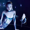 A woman in a futuristic outfit poses next to a perfume bottle. Produktbild-Vorschau