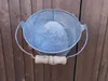 A galvanized metal bucket with a wooden handle is hanging on a wooden fence. Produktbild-Vorschau
