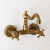 A vintage-style brass wall-mounted faucet against a white wooden background. Podgląd zdjęcia produktu