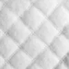 A close-up view of white quilted fabric. Náhled obrázku produktu