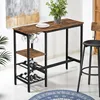 A bar table with wine glass and bottle holders in a room setting. Produktbild-Vorschau