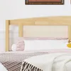 A close-up view of a bed with a wooden headboard and rattan insert, featuring striped bedding and a knitted blanket. Náhľad obrázku produktu