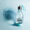 A SodaStream reusable water bottle filled with sparkling water, set against a light blue background with water bubbles. Anteprima dell’immagine prodotto