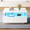 A modern white coffee table with LED lighting and decorative items on top and inside. Voir les images du produit