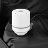 A white and gray compression pump sits on a black fabric surface, likely inside a bag. Produktbild-Vorschau