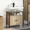 A bathroom vanity with a sink and cabinet, set against a tiled wall. Produktbild-Vorschau