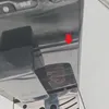 A close-up view of a coffee machine's metallic surface, with a red arrow pointing to a small detail. Produktbild-Vorschau
