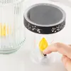 A hand is shown pressing a button on a solar-powered LED grab light next to a glass jar. Produktbild-Vorschau