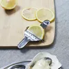 A close-up shot of lemons and a manual citrus juicer on a wooden cutting board, with an oyster in the foreground. Voir les images du produit