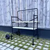 A black and white rolling scaffold with two shelves is shown outdoors on a paved area with grass. Anteprima dell’immagine prodotto