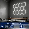 A garage or workshop setting with a car and tools, featuring a hexagonal LED light installation on the wall. Voir les images du produit