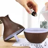 A hand is adding essential oil to an aroma diffuser that is being assembled. Produktbild-Vorschau
