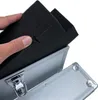 A hand is placing black foam padding into an open silver aluminum case. Produktbild-Vorschau