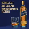 A bottle of Johnnie Walker Blue Label whisky and a glass of whisky are displayed against a dark blue background, with German text promoting the product. Produktbild-Vorschau