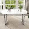 A white dining table with silver metal legs is set in a room with a large window overlooking trees and greenery. A bowl of fruit and a candle are on the table. Anteprima dell’immagine prodotto