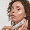A woman is applying cream from a tube to her face. Náhľad obrázku produktu