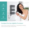 A woman is drying her hair with a towel next to a modern electric towel warmer mounted on a wall. The left side of the image displays icons and text highlighting product features. Produktbild-Vorschau