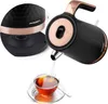 A close-up view of a black and copper electric kettle pouring water into a glass cup of tea, with an inset showing a detail of the kettle's base. Náhled obrázku produktu