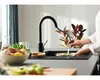 A person is washing a pan in a modern kitchen sink with a black faucet. Náhľad obrázku produktu