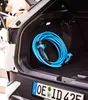 The image shows the inside of a car trunk with a blue charging cable coiled up. Náhľad obrázku produktu