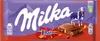 A Milka & Daim chocolate bar wrapper with a depiction of a cow and mountains. Produktbild-Vorschau