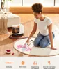 A woman is using a carpet cleaner on a rug in a living room. Náhled obrázku produktu