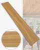 A wooden plank is shown diagonally against a blurred background of a room with windows and furniture. A close-up inset of the wood grain is also visible. Anteprima dell’immagine prodotto