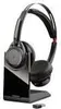 A black wireless headset with a charging dock and a USB dongle, isolated on a white background. Produktbild-Vorschau