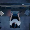 A person is working at a desk with multiple monitors, a keyboard, and a tablet. Anteprima dell’immagine prodotto