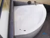 A white corner bathtub in a bathroom. Voir les images du produit