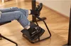 A person's legs are shown resting on a black footrest under a desk. Náhľad obrázku produktu