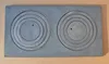 A top-down view of a cast iron stove top plate with two sets of concentric circles. Náhľad obrázku produktu