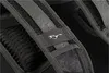 A close-up view of a backpack strap with a logo. Produktbild-Vorschau